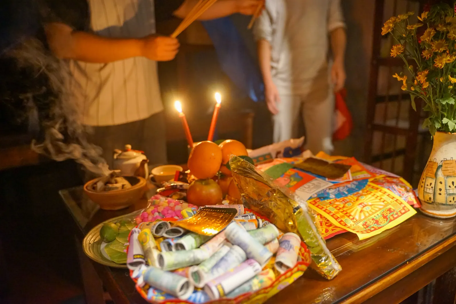Tet midnight offering altar in Hoi An with candles, incense, fruit, and joss paper ready for Lunar New Year’s Eve ritual