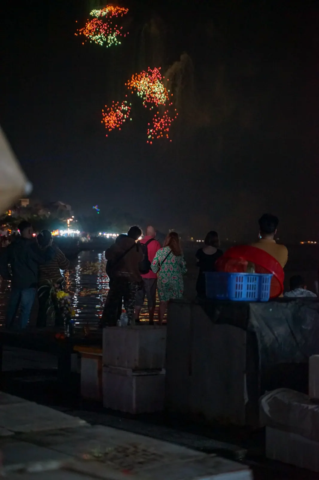 Crowd on the riverbank in Hoi An watching the midnight fireworks over the water