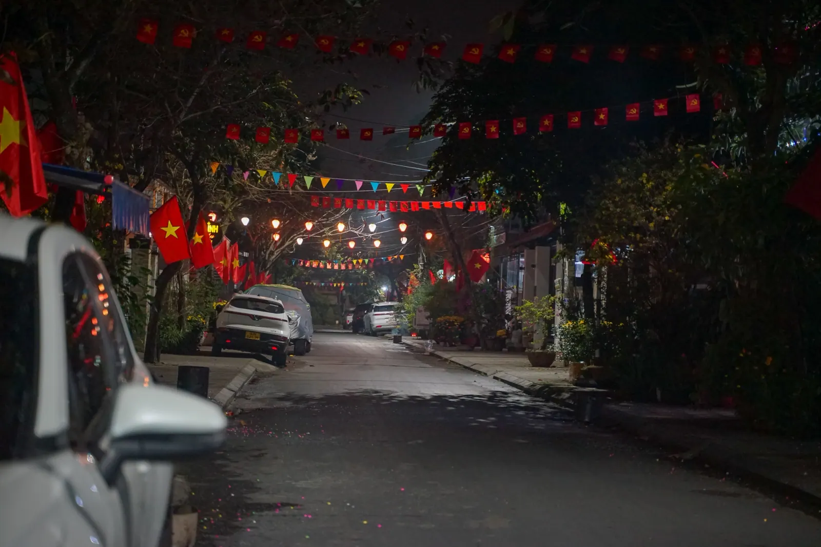 Quiet Hoi An back street strung with flags and lights, on the walk home for the first-footing